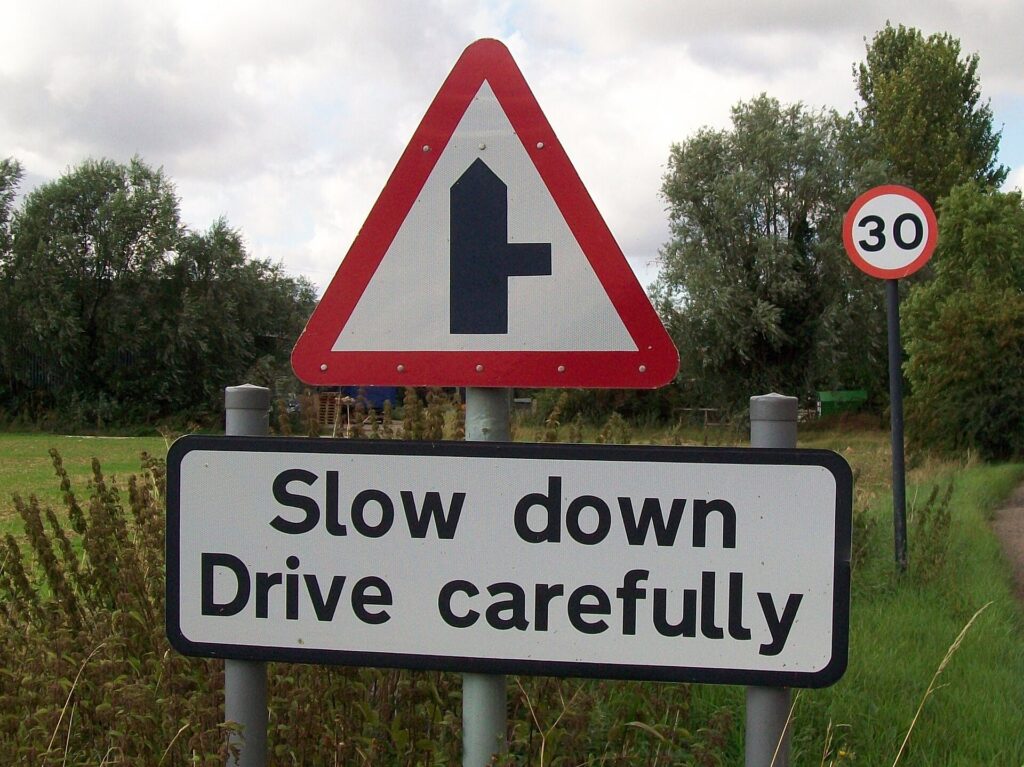 Cartello stradale "Slow down, drive carefully" in Inghilterra, per chi deve viaggiare in auto nel Regno Unito e in Irlanda