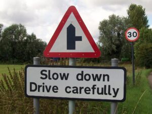Cartello stradale "Slow down, drive carefully" in Inghilterra, per chi deve viaggiare in auto nel Regno Unito e in Irlanda